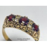 Garnet three stone carved style ring in 9ct gold, with white paste points. Hallmarked for Birmingham