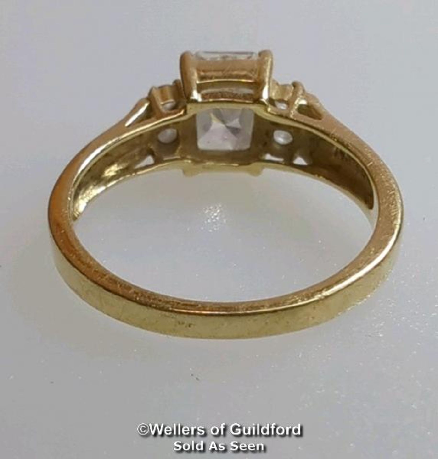 A cubic zirconia dress ring in hallmarked 14ct gold. The emerald cut centre stone measures 7mm x 5. - Image 6 of 8