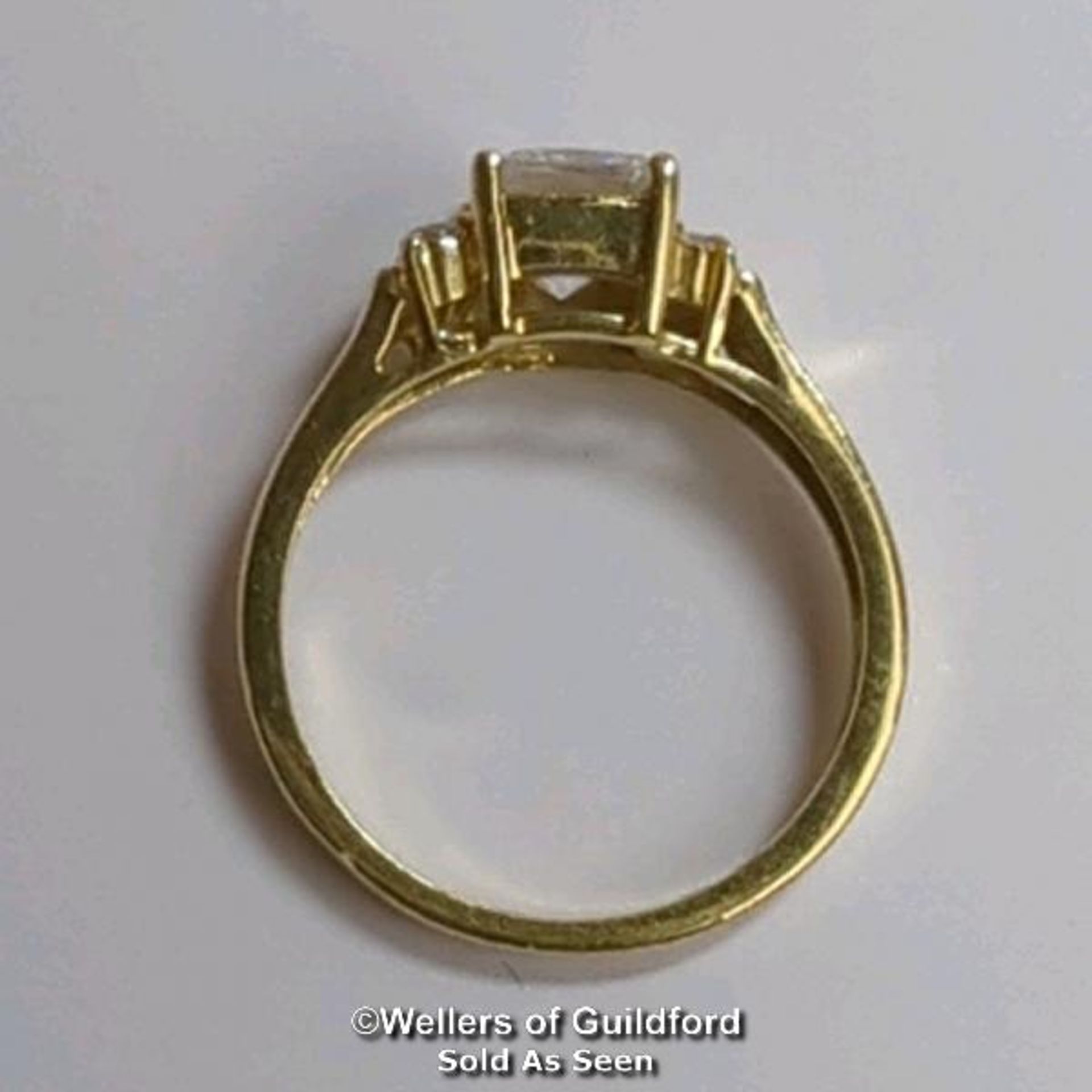 A cubic zirconia dress ring in hallmarked 14ct gold. The emerald cut centre stone measures 7mm x 5. - Image 3 of 8
