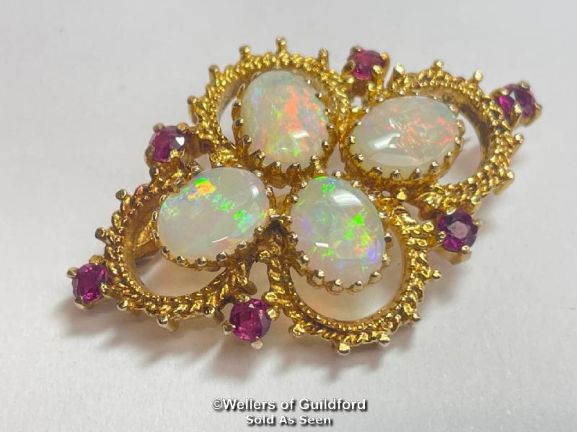 Opal and ruby quatrefoil brooch in 9ct gold. Opals measure approx 9mm x 7mm. Hallmarks for Sheffield
