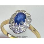 Sapphire and diamond cluster ring. An oval sapphire estimated weight 0.55ct surrounded by ten single
