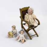 Babypuppe mit modellierter Haube auf Klappstuhl, dazu 2 Heubach-Figuren.