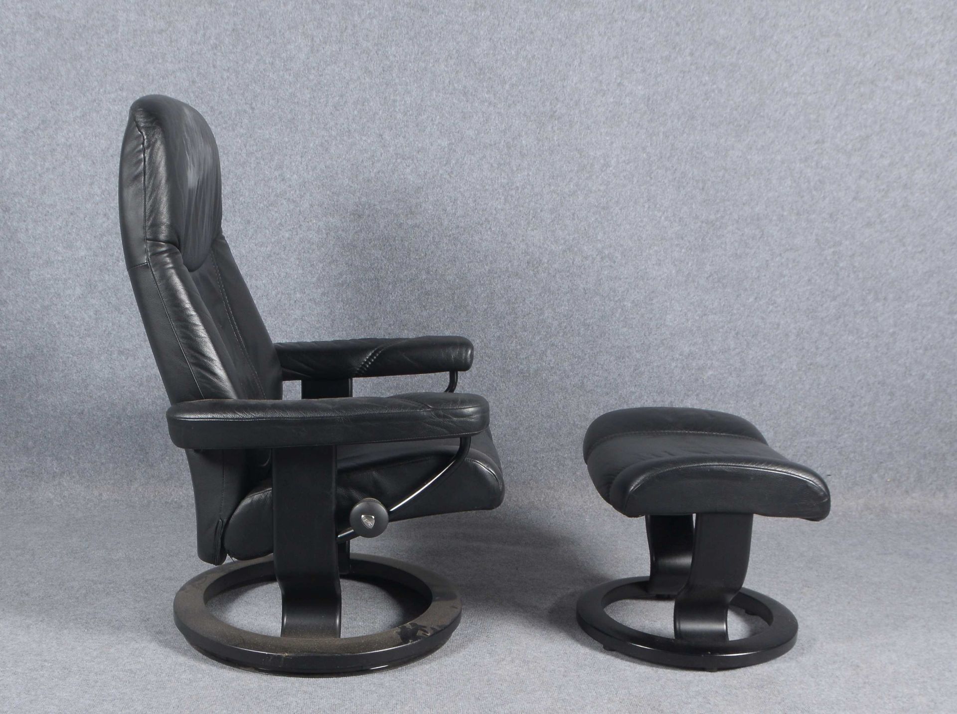 Stressless-Sessel, schwarzes Leder, auf rundem drehbarem Fu&szlig;, mit Hocker