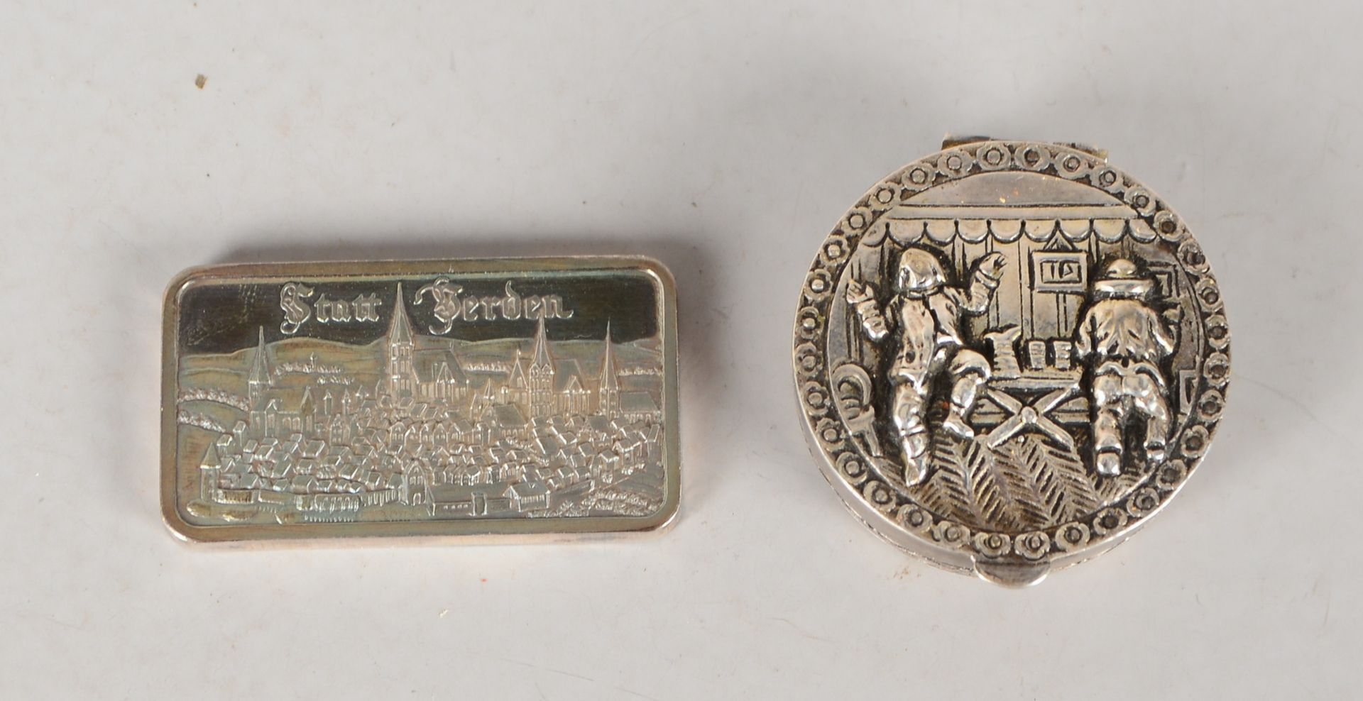 Pillendose, 800 Silber, Deckel mit Reliefmotiv, und Heraeus-Barren, 999 Feinsilber