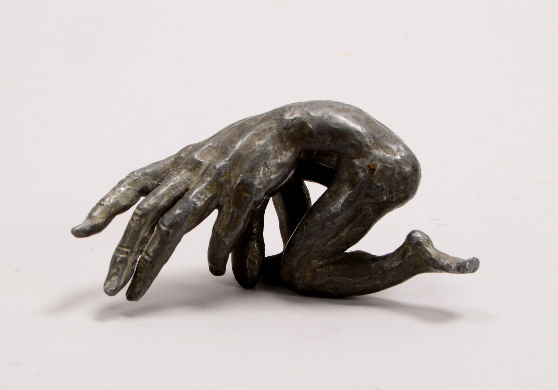 Schwarze, Michael, Metallguss-Skulptur, &#039;Handmensch - halb liegend&#039;; Breite ca. 10 cm