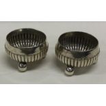 A pair of circular silver salts with fluted decora
