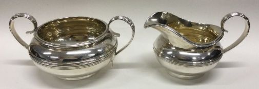 A heavy circular silver cream jug together with ma