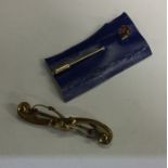 A small gold brooch together with a stick pin. App
