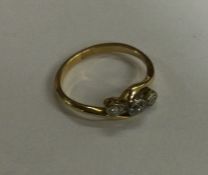 An 18 carat gold three stone diamond crossover rin