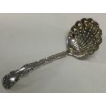 A decorative silver pierced sifter spoon with chased border. Sheffield 1906. By Henry Wilkinson.