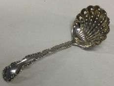 A decorative silver pierced sifter spoon with chased border. Sheffield 1906. By Henry Wilkinson.