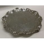 A circular silver waiter with floral decoration. S