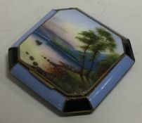 An enamelled silver plated compact decorated with a river scene. Est. £30 - £50.