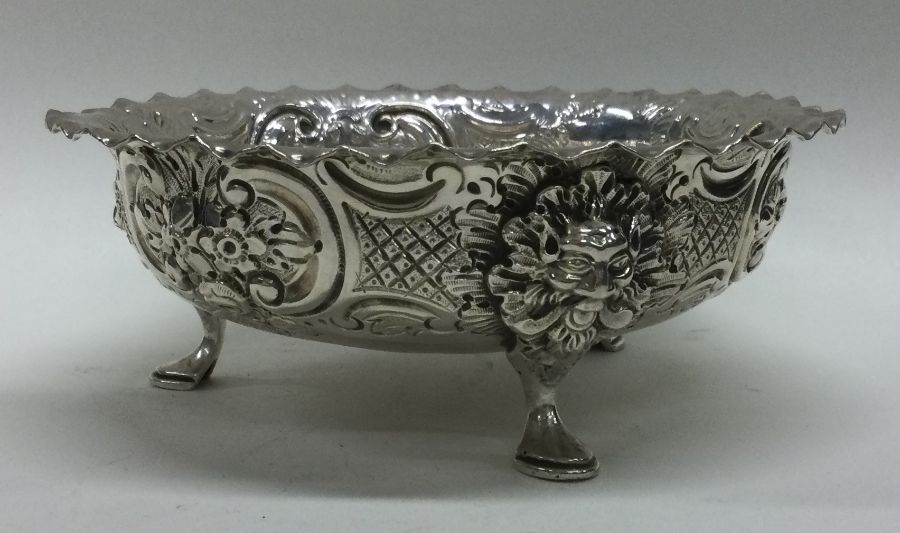 A good chased Victorian silver bowl on feet cast with lion masks. London 1889. By Charles Edwards.