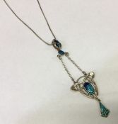 A silver and enamelled pendant on chain of stylise