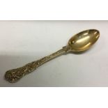 A heavy Bacchanalian pattern Victorian silver gilt dessert spoon.  London 1893. Approx. 75 grams.