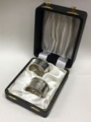 A cased pair of engraved silver napkin rings. Shef