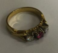 An attractive ruby and diamond three stone ring in 18 carat gold claw mount. Approx. 5 grams