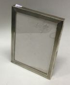 A silver mounted glass engine turned silver frame. Birmingham 1921. By S&M. Est. £50 - £80.