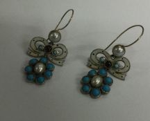 A pair of stylish turquoise and enamel earrings wi