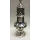 A large silver sugar caster with half fluted decor