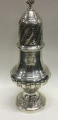 A large silver sugar caster with half fluted decor