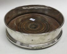 A silver and wood wine coaster. London 1969. By Roberts and Dore Ltd. Est. £80 - £120.
