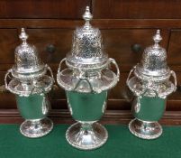 A good garniture of three silver sugar casters wit