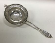 An American silver tea strainer chased with flowers. Marked Sterling. Approx. 22 grams. Est. £