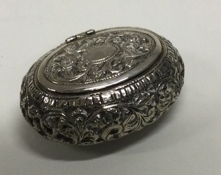 A Continental hinged silver box with chased decoration. Approx. 53 grams. Est. £40 - £60.