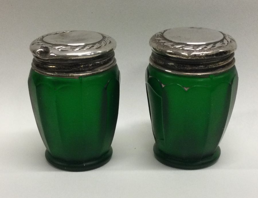 A pair of silver mounted green glass jars. Birmingham 1926. Est. £20 - £30.
