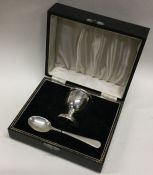 A cased silver egg cup and spoon. Birmingham 1957. Approx. 58 grams. Est. £50 - £80.