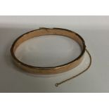 A 9 carat hinged bangle. Approx. 7.8 grams. Est. £