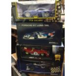 Four various boxed model racing cars, scale 1:18.
