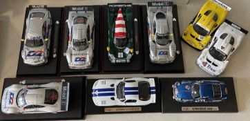 Nine various unboxed 1:18 scale model racing cars.