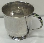 A novelty silver and enamel mug with hammered decoration. London 1927. By Bernard