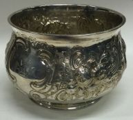A large Georgian style silver sugar bowl chased with flowers and leaves. London.