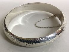 A heavy silver bracelet with engraved decoration. Approx.19 grams. Est. £20 - £30.