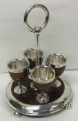 An unusual set of four Victorian silver and wooden egg cups on stand. London 1877.