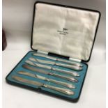 A boxed set of six silver plated tea knives. Est £10 - £20.