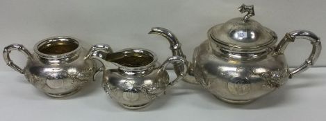 A Chinese silver three piece tea set decorated with dragons. Circa 1880.