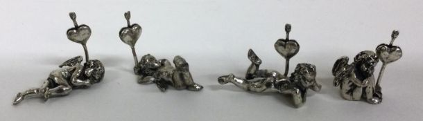 A set of four silver menu holders with cherub decoration. Approx. 51 grams.