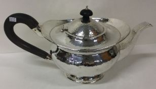 A heavy silver teapot of hammered design. Birmingham 1926. By Henry Williamson Ltd.
