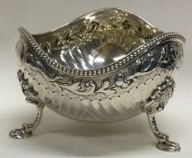 A shaped silver sugar bowl on three feet. London. By GA. Approx. 164 grams. Est. £80