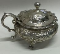 A good heavy Georgian silver embossed mustard pot with floral decoration. London.