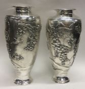 MEIJI: A fine and rare pair of Japanese silver vases embossed with trees and butterflies.