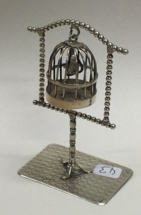 A large novelty silver bird cage on stand.