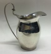 A Georgian style silver cream jug with loop handle. London. Approx. 76 grams.
