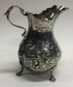 EXETER: A heavy chased silver cream jug. By JW. Approx. 73 grams.
