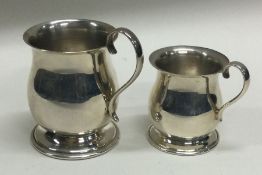 A pair of tapering silver miniature mugs London. Approx. 66 grams. Est. £30 - £50.